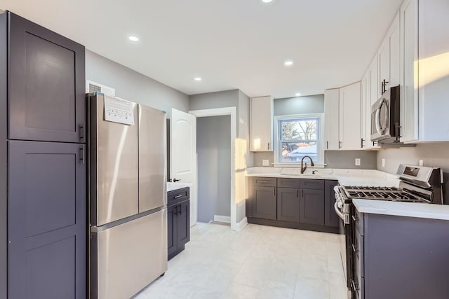 kitchen with sink, appliances with stainless steel finishes, and white cabinetry