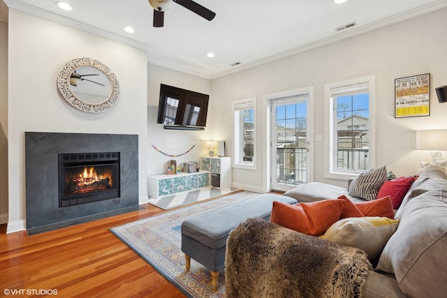 living room with ceiling fan, crown molding, and hardwood / wood-style floors