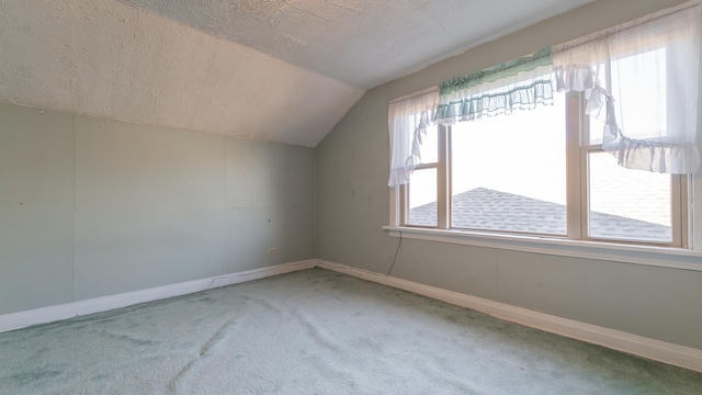 additional living space with carpet, a textured ceiling, and vaulted ceiling