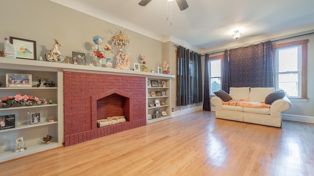 living room with built in shelves, crown molding, a fireplace, and wood-type flooring