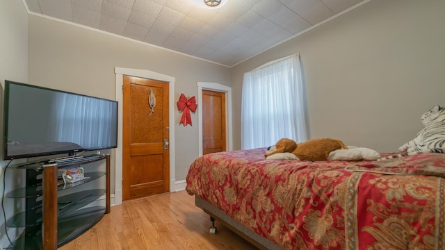 bedroom featuring crown molding and light wood-type flooring