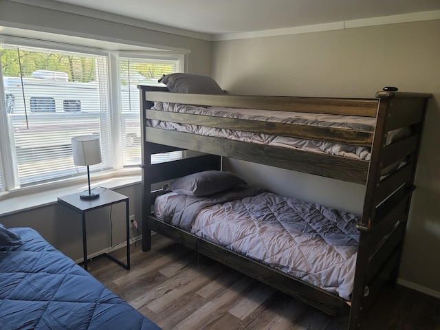 bedroom featuring multiple windows, crown molding, and wood-type flooring