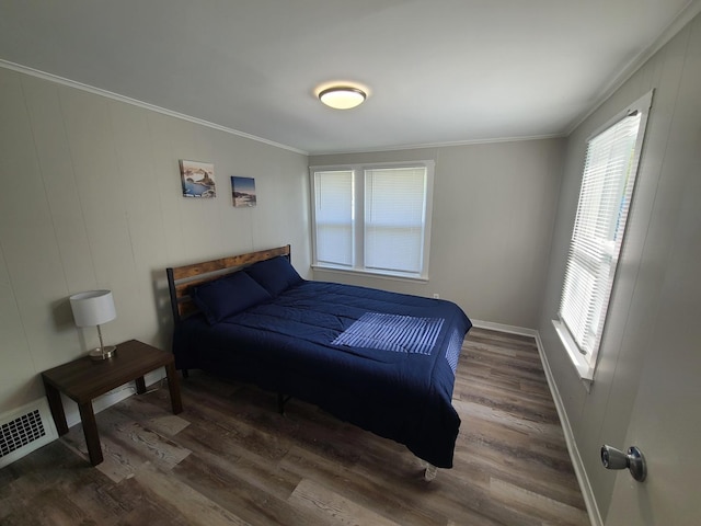 bedroom with crown molding and dark hardwood / wood-style floors