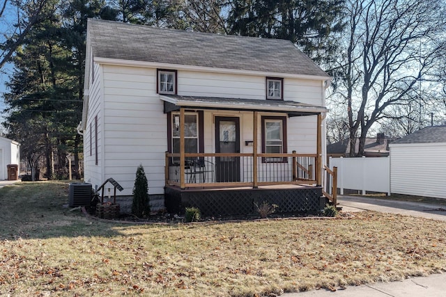 view of front facade with covered porch, central air condition unit, and a front lawn