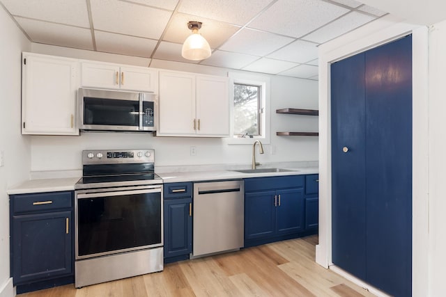 kitchen with blue cabinets, sink, light hardwood / wood-style flooring, white cabinetry, and stainless steel appliances