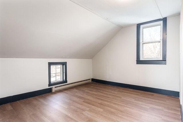 bonus room featuring light hardwood / wood-style flooring, baseboard heating, and vaulted ceiling