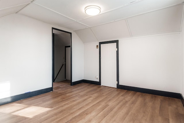 unfurnished room with light hardwood / wood-style floors and lofted ceiling