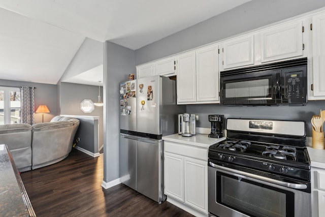 kitchen with appliances with stainless steel finishes, vaulted ceiling, dark hardwood / wood-style flooring, and white cabinetry