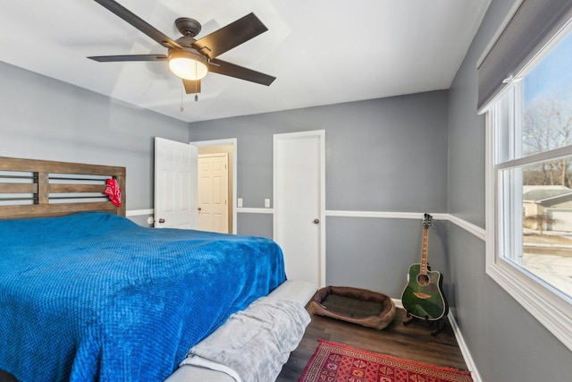 bedroom with ceiling fan, multiple windows, and hardwood / wood-style flooring