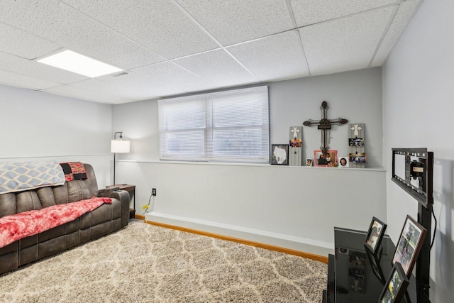 living room with a paneled ceiling and carpet