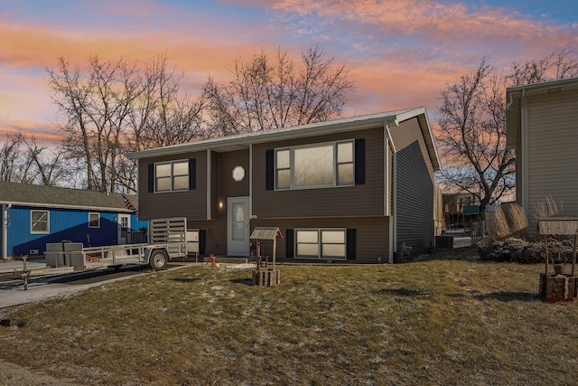 split foyer home featuring a yard