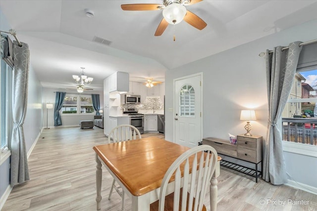 dining space with lofted ceiling, ceiling fan, and light wood-type flooring