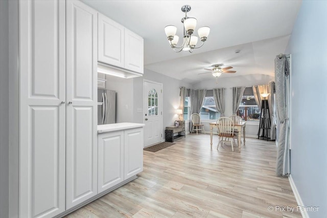 interior space with ceiling fan with notable chandelier and light wood-type flooring