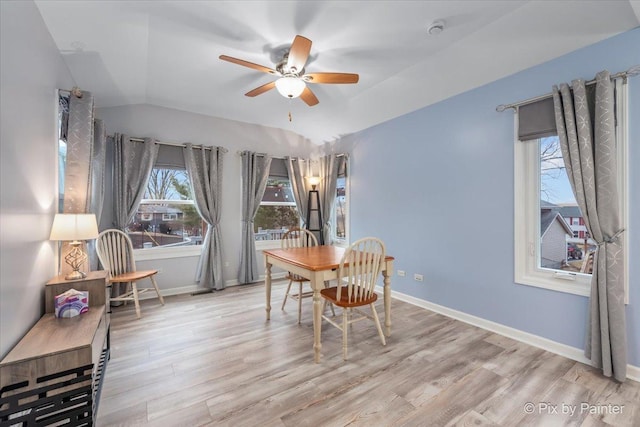 dining space featuring ceiling fan, light hardwood / wood-style floors, and vaulted ceiling