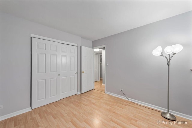 unfurnished bedroom featuring light hardwood / wood-style floors and a closet