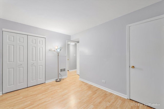 unfurnished bedroom with a closet and light hardwood / wood-style flooring