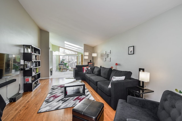 living room featuring vaulted ceiling and light hardwood / wood-style flooring