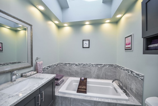 bathroom with vanity and a relaxing tiled tub