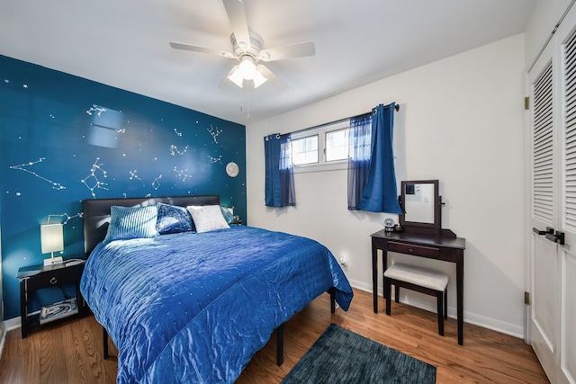 bedroom featuring wood-type flooring, ceiling fan, and a closet