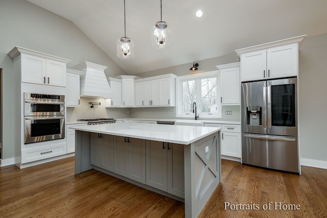 kitchen with white cabinets, a center island, stainless steel appliances, and premium range hood