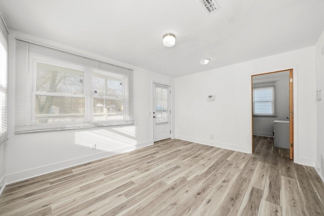 empty room featuring plenty of natural light and light hardwood / wood-style flooring