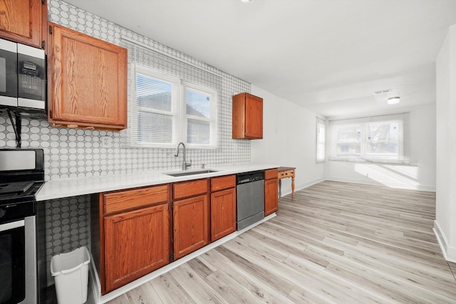 kitchen featuring backsplash, a healthy amount of sunlight, sink, and stainless steel appliances