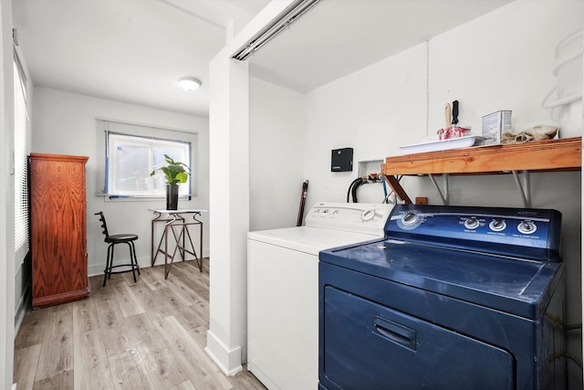 clothes washing area featuring washer and clothes dryer and light hardwood / wood-style flooring