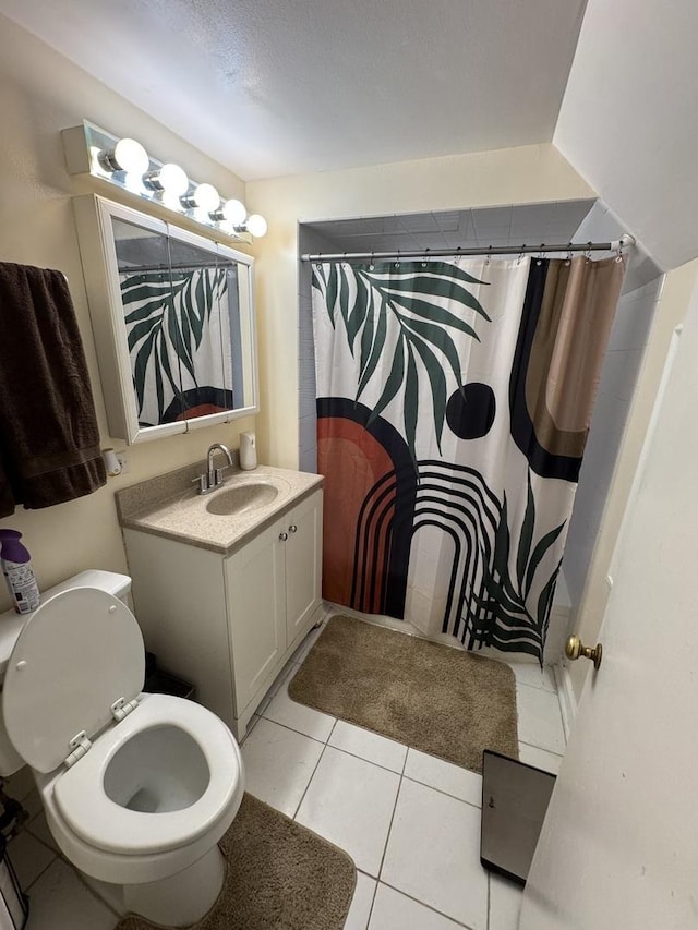 bathroom featuring tile patterned flooring, vanity, toilet, and walk in shower