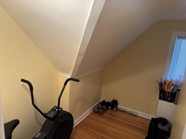 workout area featuring hardwood / wood-style flooring and lofted ceiling