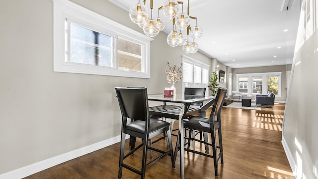 dining room with dark wood-type flooring and an inviting chandelier