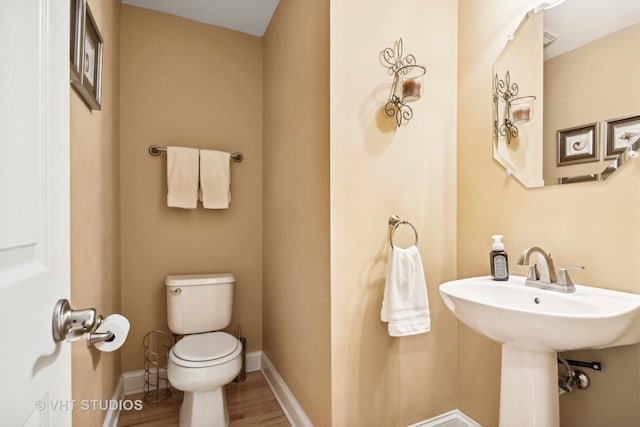 bathroom featuring sink, hardwood / wood-style floors, and toilet