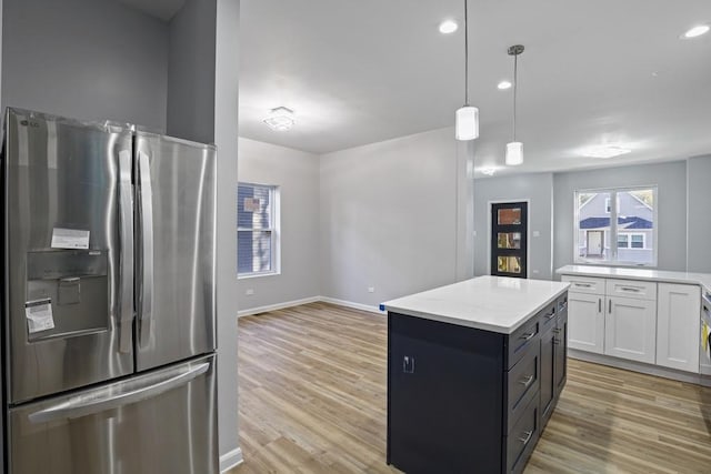 kitchen featuring decorative light fixtures, white cabinets, stainless steel fridge with ice dispenser, light hardwood / wood-style floors, and a kitchen island