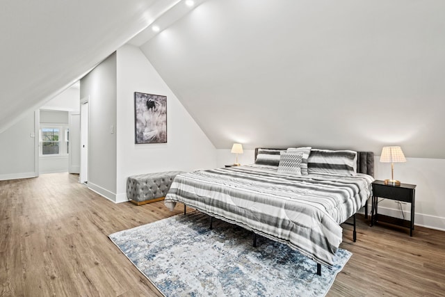 bedroom with hardwood / wood-style flooring and lofted ceiling