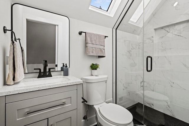 bathroom featuring lofted ceiling with skylight, vanity, a shower with shower door, and toilet