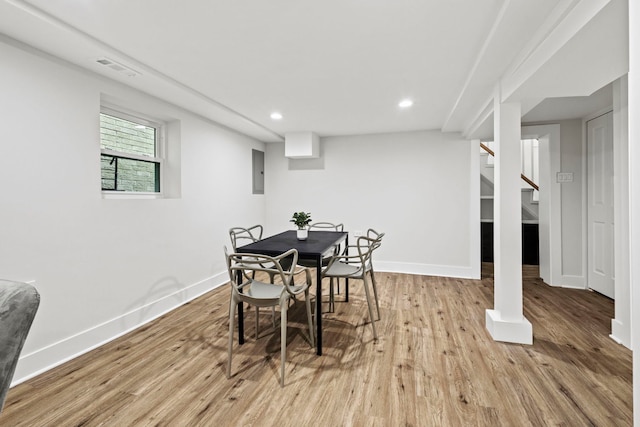 dining space featuring electric panel and light hardwood / wood-style flooring