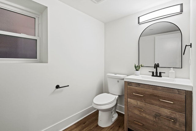 bathroom featuring vanity, wood-type flooring, and toilet