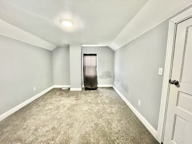 additional living space with vaulted ceiling and light carpet