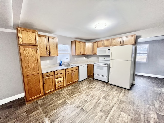 kitchen with sink, white appliances, and light wood-type flooring