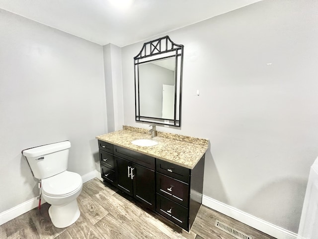 bathroom with vanity, hardwood / wood-style floors, and toilet