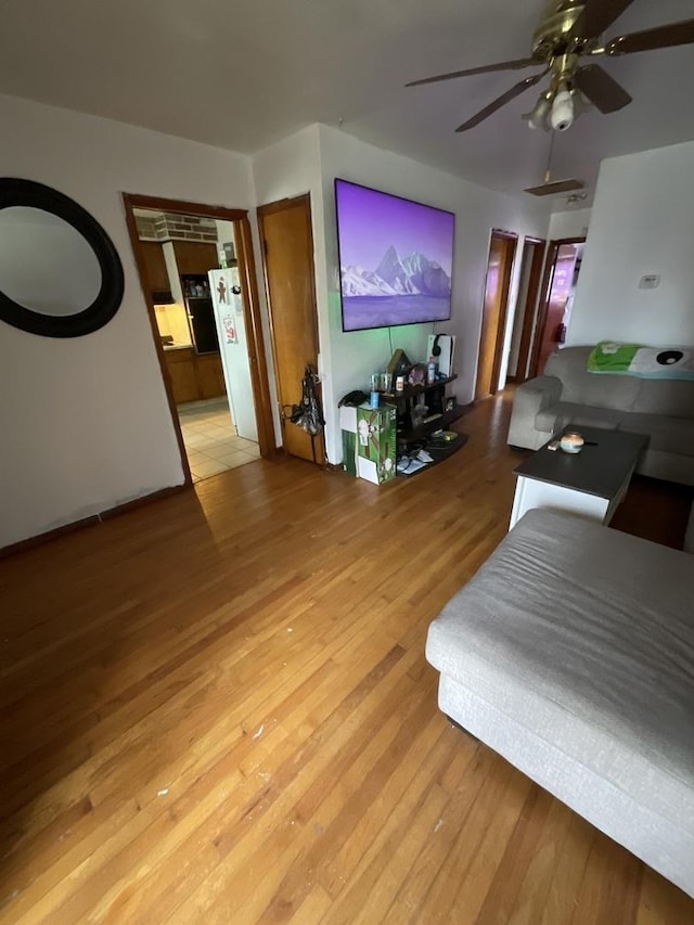 living room with ceiling fan and light hardwood / wood-style flooring