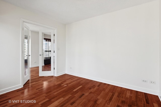 empty room with hardwood / wood-style flooring and french doors