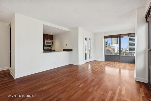 unfurnished living room with french doors, a textured ceiling, and hardwood / wood-style flooring