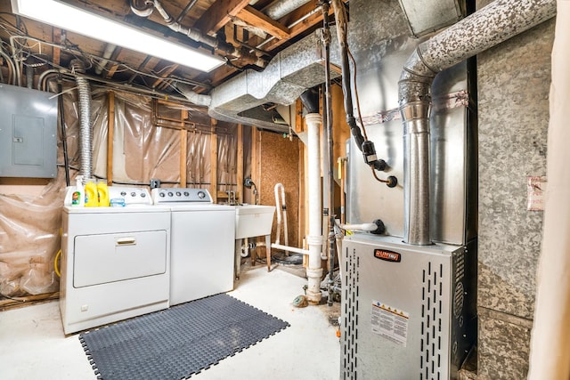 washroom with washing machine and dryer, electric panel, and sink