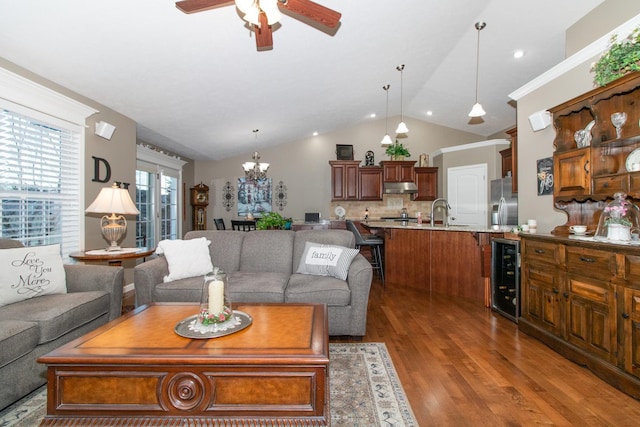 living room with sink, wine cooler, dark hardwood / wood-style flooring, ceiling fan with notable chandelier, and vaulted ceiling