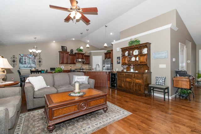 living room with dark hardwood / wood-style floors, ceiling fan with notable chandelier, lofted ceiling, sink, and wine cooler