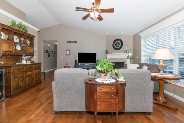 living room featuring hardwood / wood-style floors, vaulted ceiling, and ceiling fan