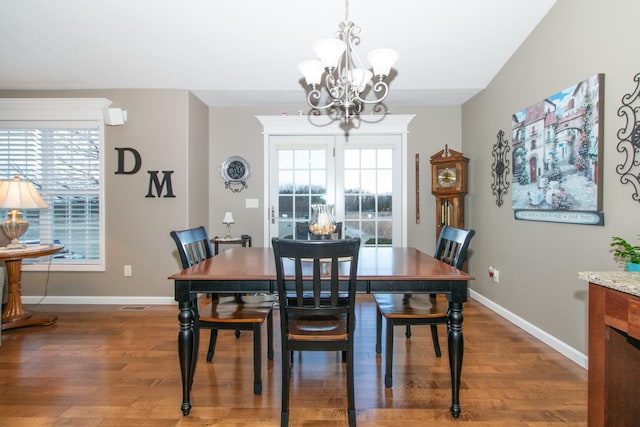 dining area featuring an inviting chandelier and dark hardwood / wood-style floors