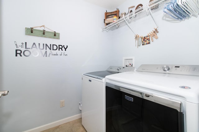 clothes washing area featuring light tile patterned flooring and washing machine and dryer