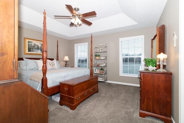 bedroom featuring carpet floors, a raised ceiling, and ceiling fan