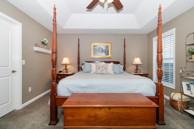 bedroom with a tray ceiling, ceiling fan, and carpet